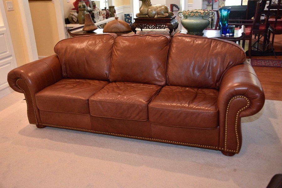 encased in genuine leather this rolled arm sofa