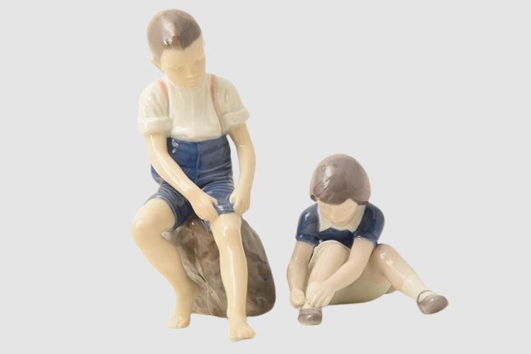 Bing & Grondahl Boy sitting on stone rolling up trousers / Girl Lacing Her Shoes