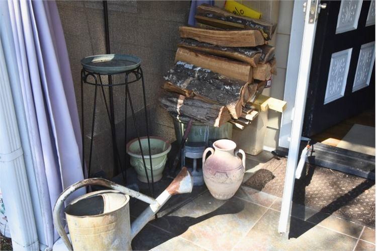 Porch with Firewood, Plant Stands, Pots, and Watering Can