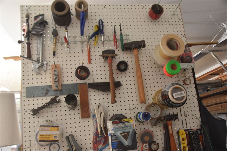 Pegboard Wall with Various Tools and Supplies: Hammers, Wrenches, and Tape